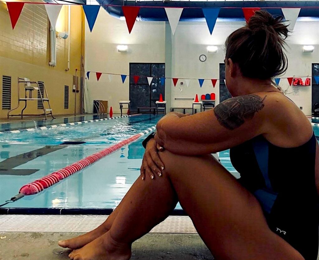 Crystal Billings, a wellness coach, sitting poolside, reflecting on health coaching and wellness journey for balance.