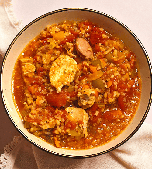 A hearty bowl of jambalaya with chicken and sausage, a delicious and nourishing meal from a wellness coaching recipe collection.